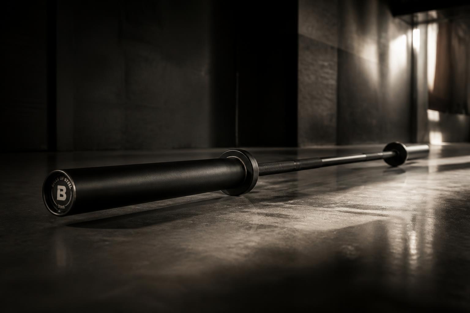 Matte black olympic barbell on polished concrete